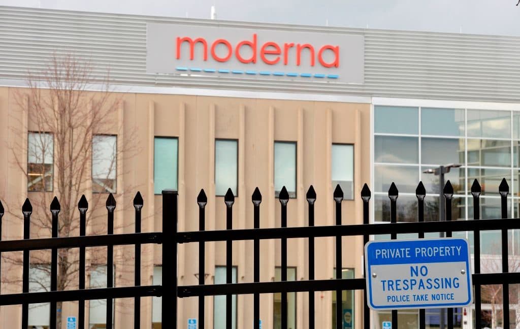 Image of a building with the Moderna logo behind a security fence.