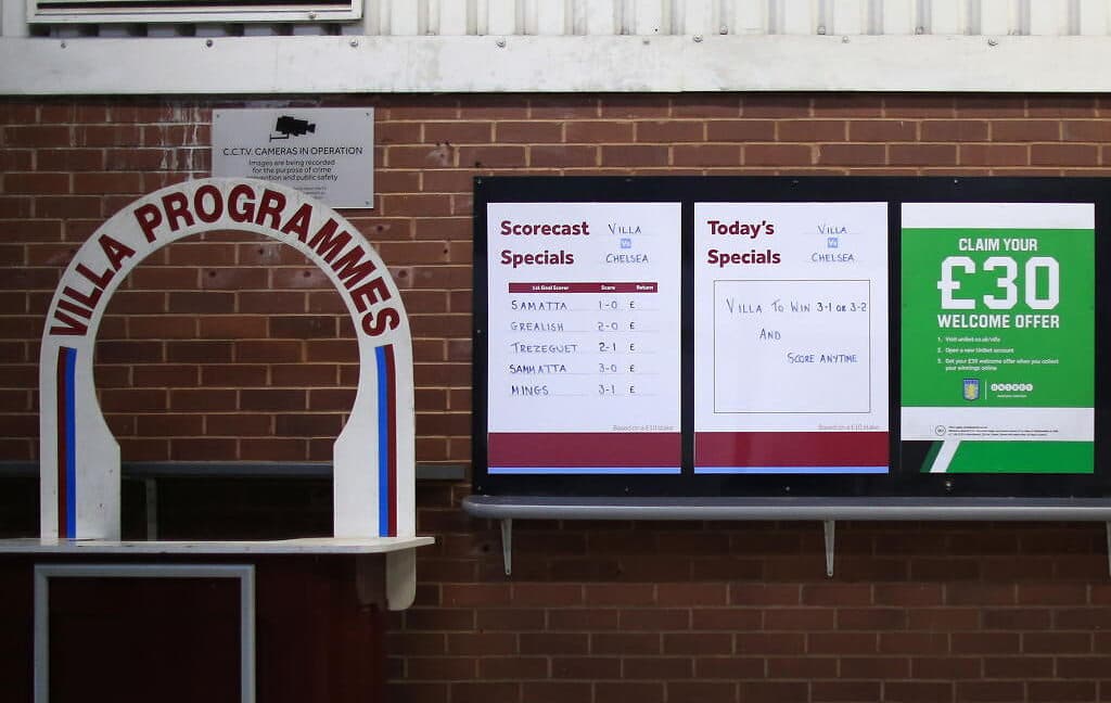 A ticket window with betting odds next to it