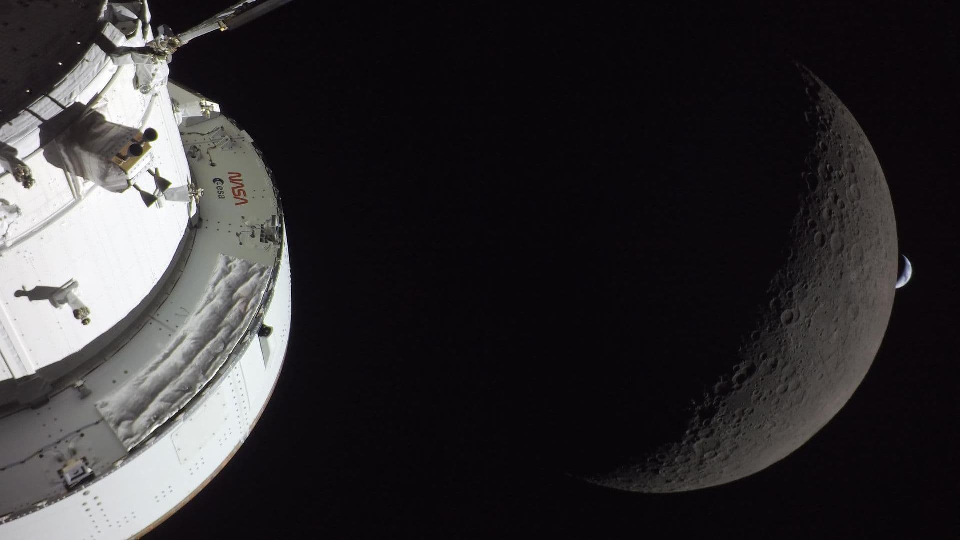 a white nasa and esa spacecraft with the moon and a crescent earth in the background