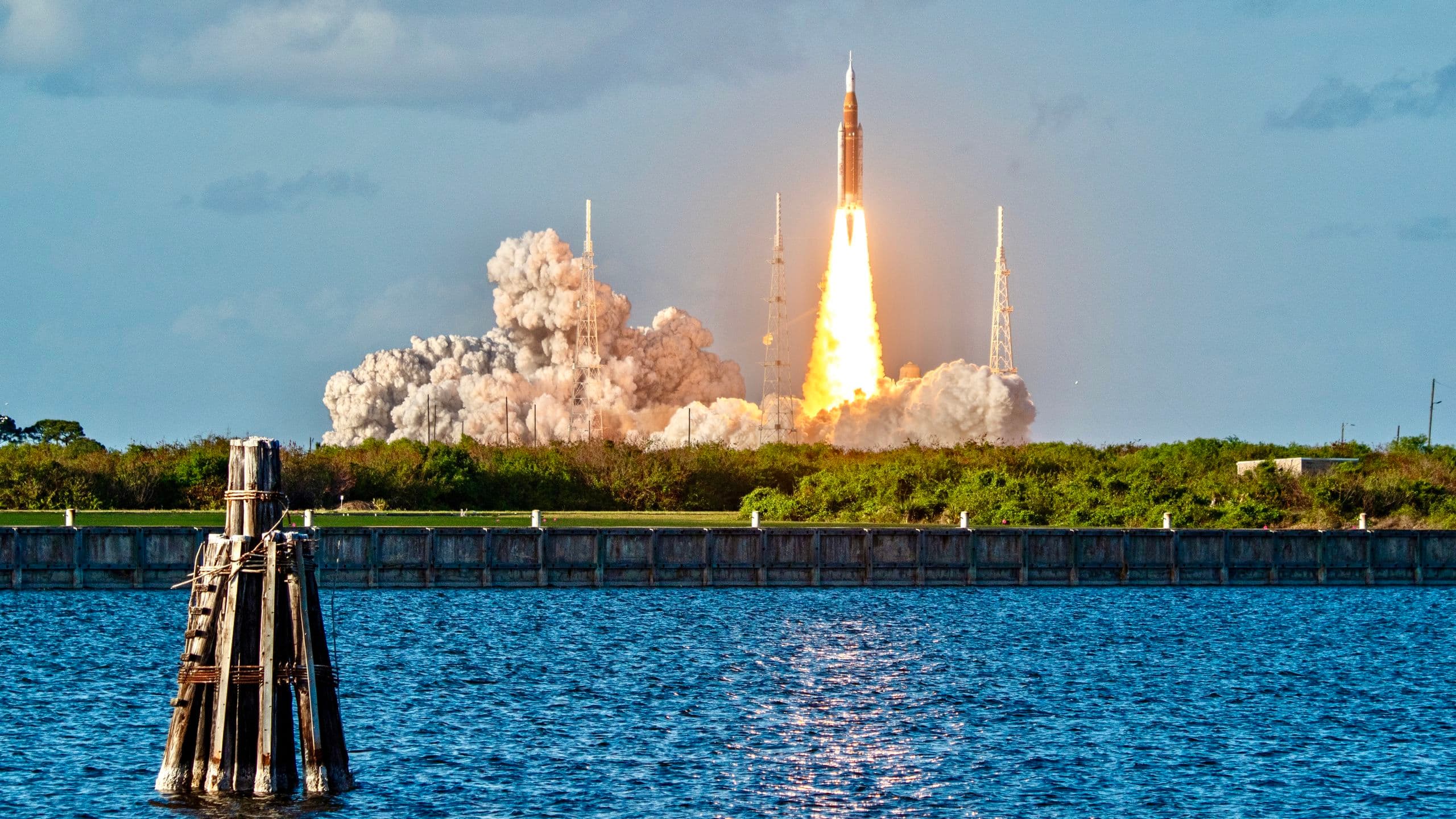 a rocket launches above a plume of fire