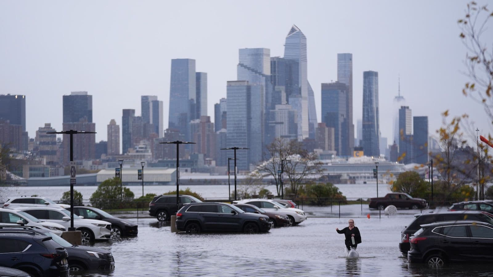 Cars submerged in flood water with New York City in the background
