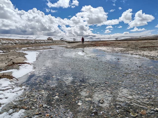 Scientist looks over icy river on Qinghai-Tibet Plateau (via seismosoc.org)