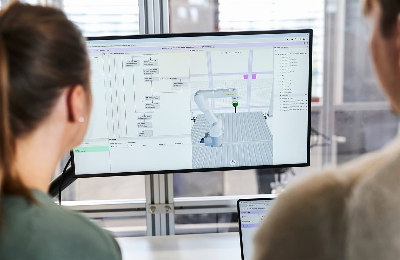 Two people looking at the Intrinsic Flowstate interface on a computer screen. 