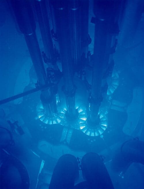 The Advanced Test Reactor at Idaho National Laboratory, glowing blue with Cherenkov radiation. Argonne National Laboratory. CC BY-SA 2.0, via Wikimedia Commons.
